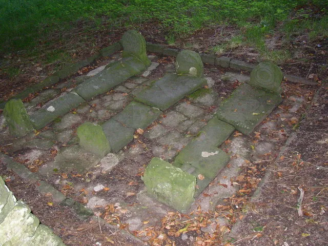 Gravestones, St Michael's Church, Llanfihangel abercywyn, St Clears An interesting group of three gravestones. The one on the left has a sword carved along its length, whilst the one on the left has two feet below what looks like the hem of a dress  male and female?