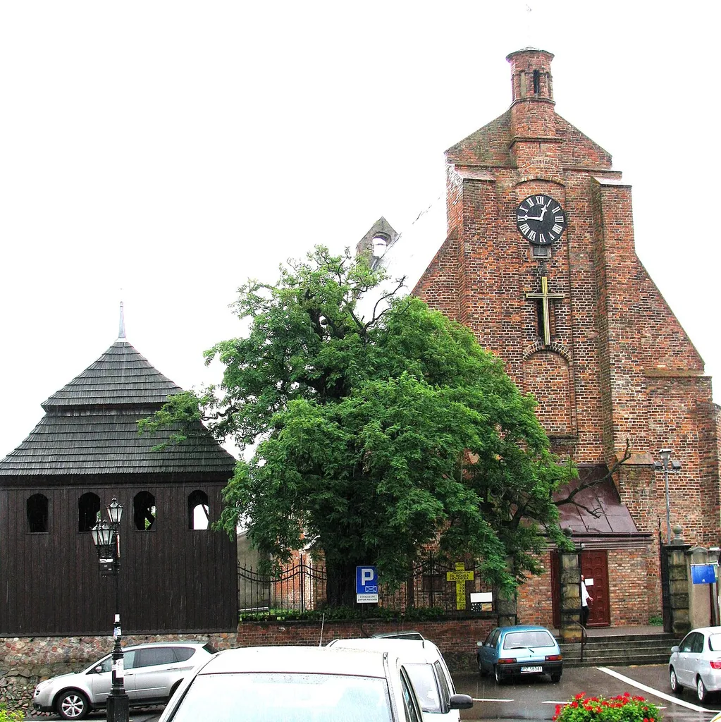 Church of the Archangel Saint Michael, Pobiedziska, Poland. The church is close to the Rynek and dates from the thirteenth century, with the adjacent wooden bell tower dating from the nineteenth century.The Scotch Mist Gallery contains many photographs of historic buildings, monuments and memorials of Poland.