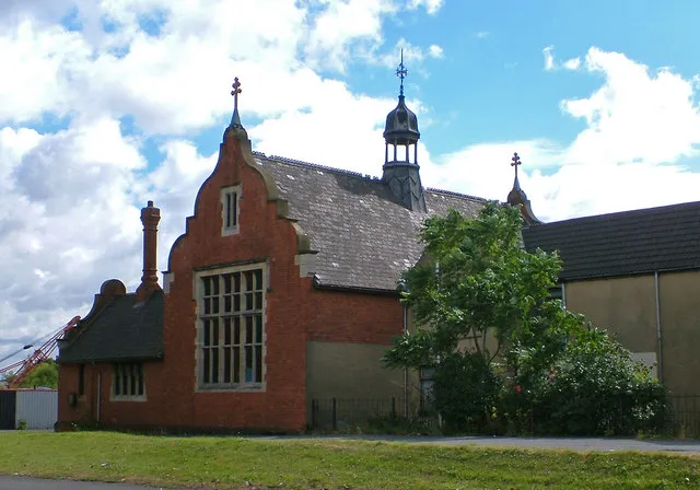 Ukrainian Catholic Church, Scunthorpe. Pevsner says "UKRAINIAN CATHOLIC CHURCH OF THE HOLY CROSS, High Street East, Scunthorpe. 1894 by James Thropp, the Lindsey County Surveyor, built as the Police Headquarters and Magistrates' Courts. Brick and stone, Jacobean, with shaped gables and exceedingly tall polygonal chimneys.".