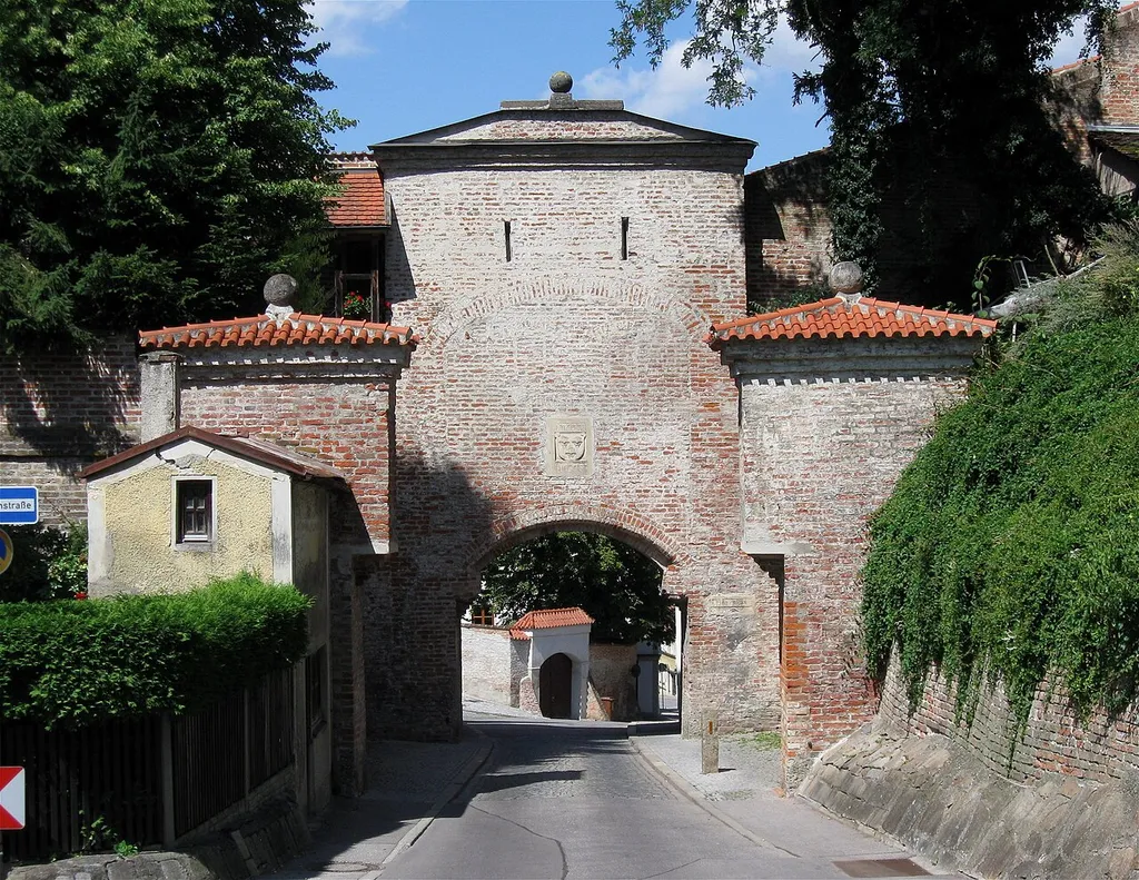 Alte Bergstraße; Burghauser Tor (Huetertor), spätgotische Toranlage der mittelalterlichen Stadtbefestigung, unverputzter Ziegelbau mit Wappen, 1. Hälfte des 14. Jh., um 1800 klassizistisch umgestaltet.
