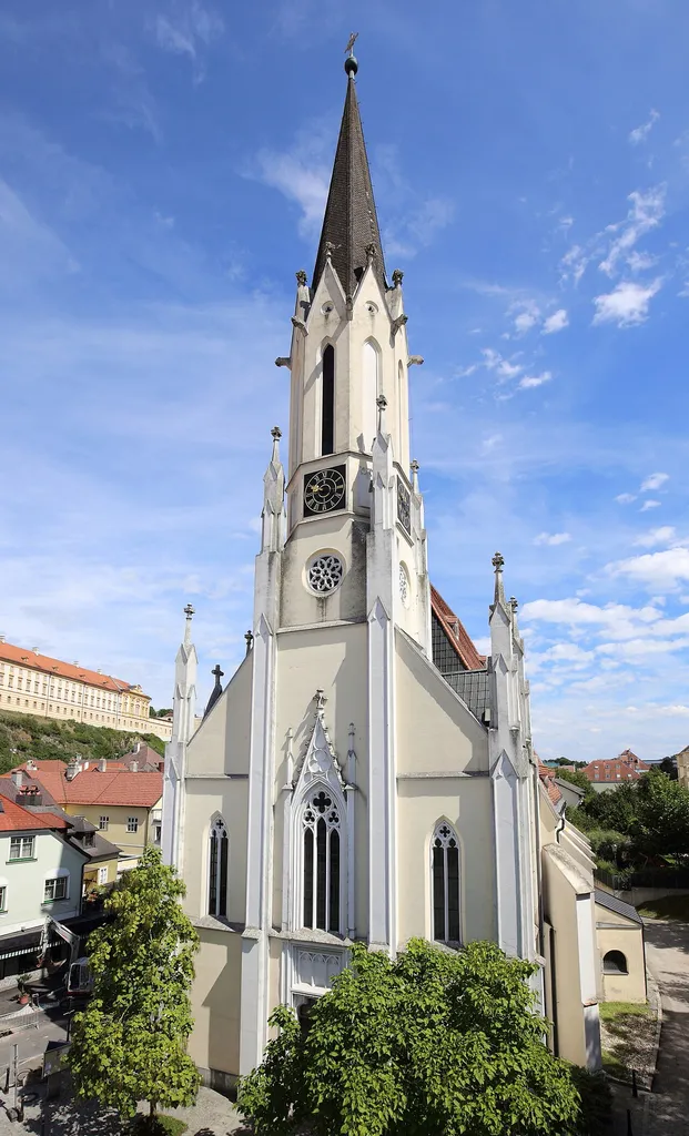Katholische Pfarrkirche Mariae Himmelfahrt der niederösterreichischen Bezirkshauptstadt Melk. Eine spätgotische Kirche aus dem 15. Jahrhundert mit einem eingezogenen Chor. Nach dem Turmbrand 1847 wurde von 1868 bis 1877 der Turm und ein dreiachsiger, dreizoniger Turmvorbau neu errichtet.