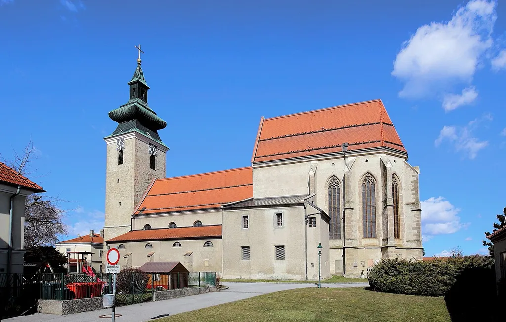 Südansicht der katholischen Pfarrkirche hl. Martin in der niederösterreichischen Marktgemeinde Pillichsdorf. Eine im Kern romanische und barockisierte Pfeilerbasilika (1. Hälfte des 13. Jahrhunderts und um 1340 gotisiert) mit hohem gotischen Langchor (um 1420) und freistehendem mächtigen spätgotischen Westturm (um 1510).