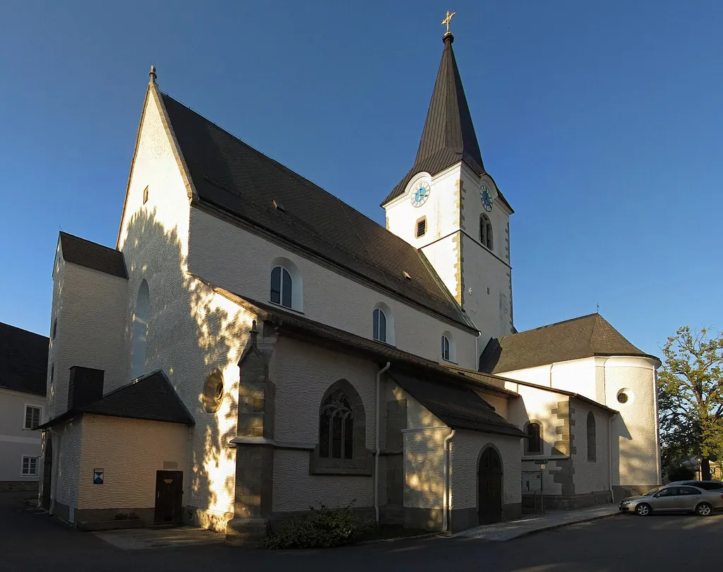 Die Anfang des 13. Jahrhunderts erbaute, ursprünglich romanische Kirche wurde im 15. Jahrhundert durch spätgotische Erweiterungsbauten zu einer dreischiffigen Basilika umgewandelt. Der Hochaltar ist ein Werk von Johann Walser aus dem Jahr 1749. Das Altarblatt eines Seitenaltars wurde 1747 von Martin Johann Schmidt gemalt. Josef Rifesser schuf 1904 die neugotischen Altäre in der Barbarakapelle.
