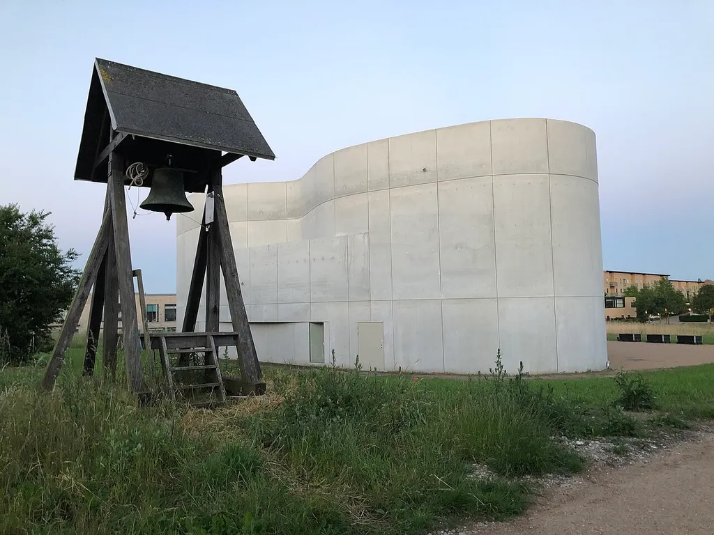 Trekroner Kirke med klokkestabel i forgrunden.