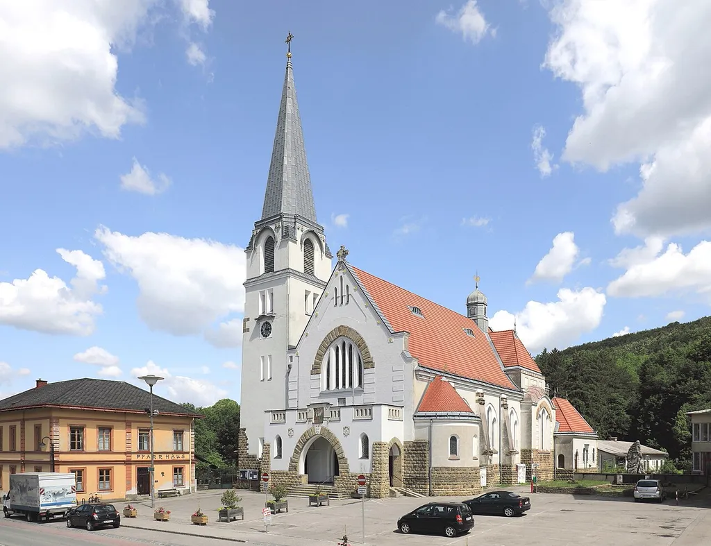 Westansicht der röm.-kath. Pfarrkirche hl. Dreifaltigkeit in der niederösterreichischen Stadtgemeinde Pressbaum mit Pfarrhof (links, 1881 errichtet) und Kriegerdenkmal (rechts).Von 1906 bis 1908 nach Plänen der Architekten Max Hegele und August Rehak als Kaiser-Franz-Joseph-Jubiläums-Kirche errichtet. Die Kirche mit ihrem speziellen Stil stellt in der Sakralarchitektur Niederösterreichs ein bedeutendes Denkmal dar und steht unter Denkmalschutz.