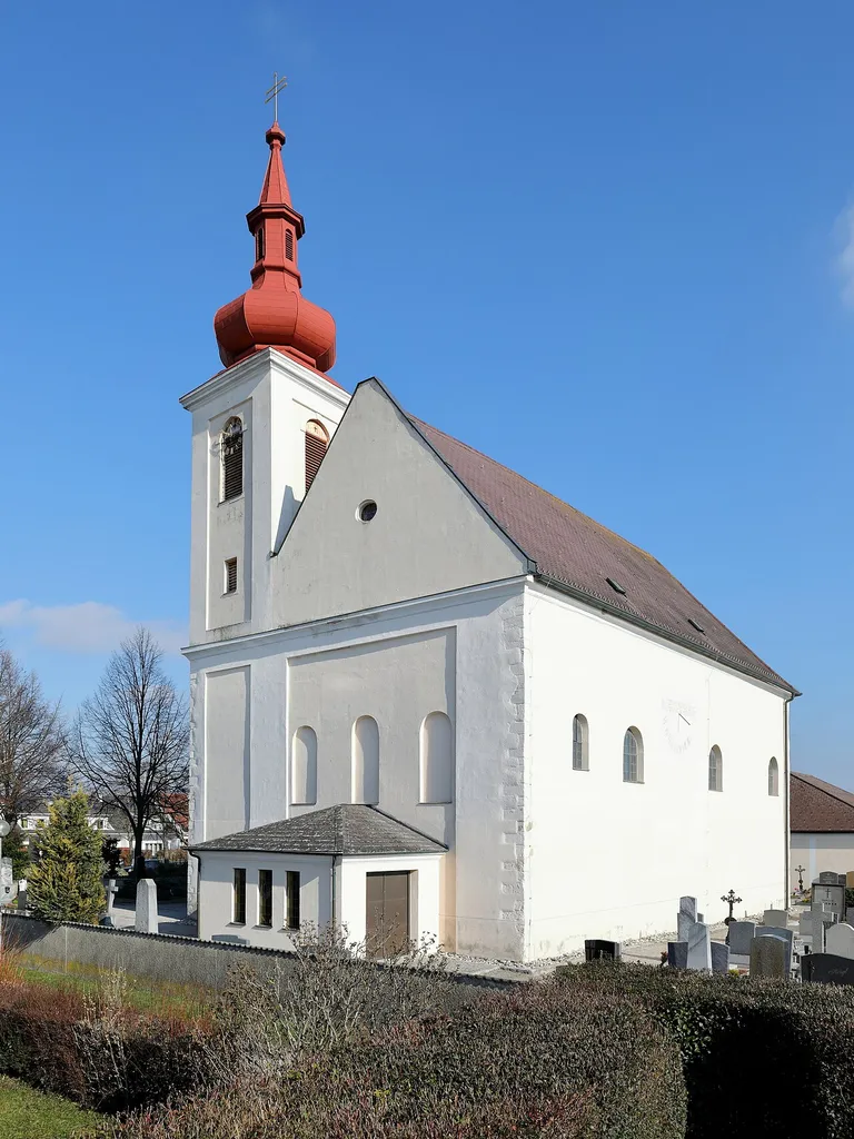 Südwestansicht der röm.-kath. Pfarrkirche hl. Helena in Langenlebarn, ein Ortsteil der niederösterreichischen Stadtgemeinde Tulln an der Donau.Das Kirchengebäude wurde von 1671 bis 1676 von Wolf Saggerer errichtet und Mitte des 20. Jahrhunderts erfolgte der Anbau der Eingangshalle.