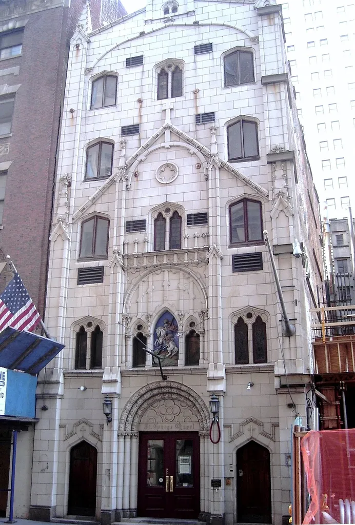 St. George's Syrian Catholic Church is a former church located at 103 Washington Street between Rector Street and Carlisle Street in the Financial District of Manhattan, New York City. The church is the last physical reminder of the Syrian- and Lebanese-American community that once lived in Little Syria. Originally three stories tall with a peaked roof, the structure was built c.1812, and by 1850 was being used as a boardinghouse for immigrants; an additional two stories were added on in 1869. In 1925, the building was purchased by George E. Bardwil, a textiles importer, for the use of the Syrian Catholic Church, organized in 1889 to serve the Syrian- and Lebanese-American community in the Little Syria neighborhood, also known as the Syrian Quarter. Four years later, Harvey F. Cassab, a Lebanese-American draftsman, was hired to create a new facade for the building. His neo-Gothic design in white terra cotta with a polychrome relief of St. George and the Dragon remains intact. (Source: "NYCLPC Desisignation Report")