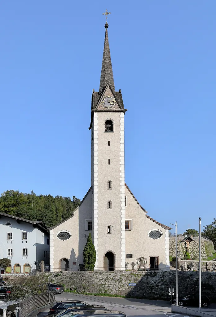 Westansicht der röm.-kath. Pfarrkirche hl. Johannes der Täufer in der Salzburger Marktgemeinde Golling an der Salzach.Ursprünglich eine einschiffige Kirche, wurde sie 1689 vom Salzburger Hofbaumeister Giovanni Gaspare Zuccalli zu einer zweischiffigen Kirche umgebaut bzw. erweitert. In dieser Zeit erfolgte auch eine Erhöhung des Kirchturmes. Die Turmkrone, eine Laterne mit Zwiebelturm, wurde 1888 nach einem Blitzschlag schwer beschädigt und erhielt danach den charakteristischen Spitzhelm.