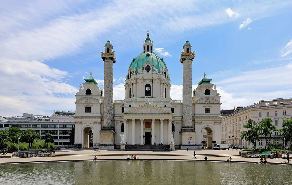 Die Karlskirche am Karlsplatz im 4. Wiener Gemeindebezirk Wieden.Die Kirche, dem heiligen Karl Borromäus geweiht, wurde anlässlich der Einlösung eines von Kaiser Karl VI. während der Pestepidemie am 22. Oktober 1713 bei St. Stephan abgelegten Gelübdes errichtet. Die Grundsteinlegung fand am 4. Februar 1716 statt und am 28. Oktober 1737 erfolgte die Weihe durch Kardinal Sigismund Graf Kollonitsch, wobei die erste Messe in feierlicher Form und in Anwesenheit des Kaisers erst am 24. August 1738 abgehalten wurde. Errichtet wurde die Kirche nach Plänen des Architekten Johann Bernhard Fischer von Erlach. Nach seinem Tod (1723) vollendete sein Sohn Joseph Emanuel Fischer von Erlach mit dem Bauführer Erhard Martinelli den Sakralbau. Die beiden Triumphsäulen sind 33 m hoch, während die Kuppel über dem längsovalen Hauptraum eine Höhe von 72 m erreicht.