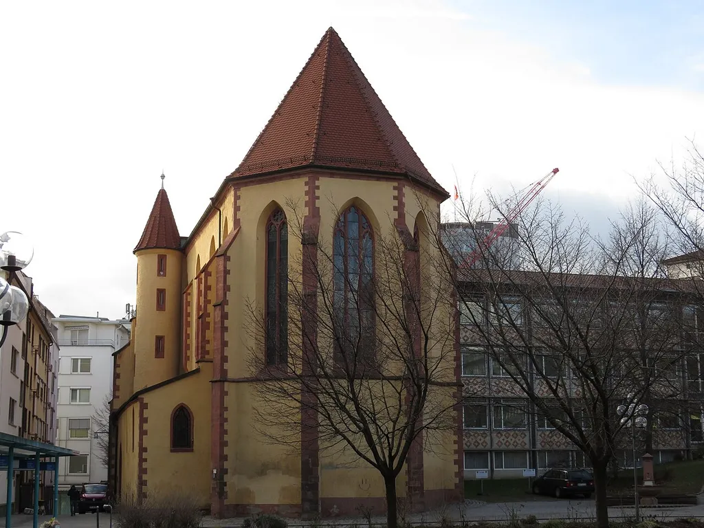 Pforzheim Barfüsserkirche gotische Maßwerkfenster Ostchor u. Diakoniebau. Das schlichte, turmlose Äußere mit hoch aufstrebenden Strebepfeilern und Maßwerkfenstern ist typisch für die frühe gotische Bettelordensarchitektur. Zu dem ursprünglich den Mönchen vorbehaltenen Langchor gehören auf der Südseite die Sakristei und ein Treppenturm, der 1939 nach Befunden rekonstruiert wurde.
