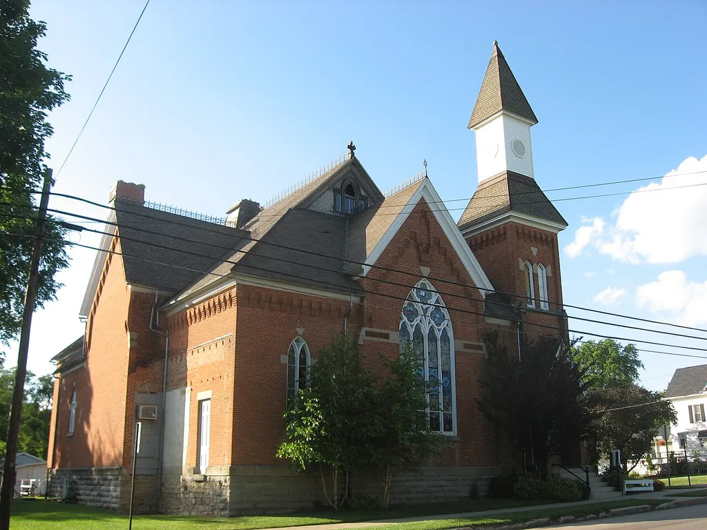 Front and southwestern side of the Mechanicsburg Baptist Church, located on the western corner of the intersection of Sandusky (State Route 4) and Walnut Streets in Mechanicsburg, Ohio, United States. Built in 1890, it is listed on the National Register of Historic Places.