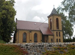 Kirche (mit Ausstattung), Kirchhof mit Einfriedungsmauer, Denkmal für die Gefallenen des 1. Weltkrieges und Grabmal Anders sowie lindenbestandene Zuwegung zur Kirche Neue Grimmaer Straße -
