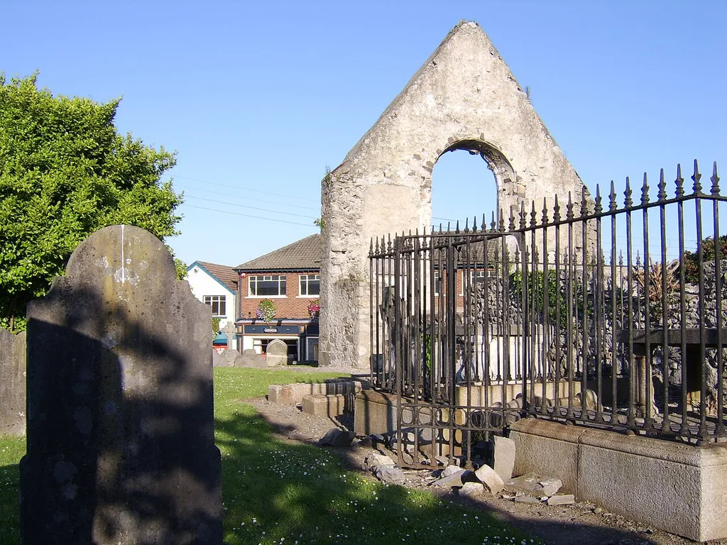 This small plain church replaced an earlier building on a site which may have held a Christian base since the 6th century; it was replaced by All Saints Church, sponsored by the Guinness family; this view shows one end of the building and some graves