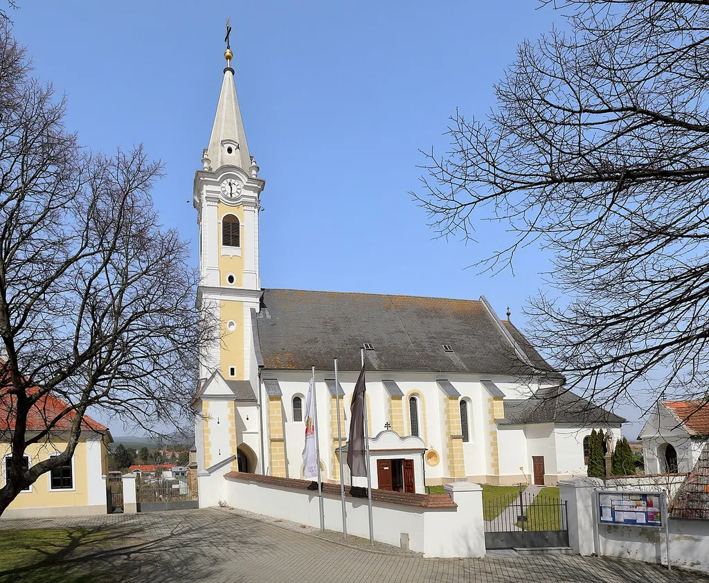 Südansicht der röm.-kath. Pfarrkirche hl. Andreas in der burgenländischen Marktgemeinde Draßmarkt.Die Kirche wurde auf einem Hügel im Ort errichtet. Sie ist ein Saalbau aus dem 16. Jahrhundert mit barocken Veränderungen und wurde 1899 erweitert. An das fünfjochige Schiff schließt im Westen ein dreigeschoßiger Turm mit Steinhelm an. Im Innenraum finden sich barocke Heiligenfiguren sowie ein moderner Volksaltar.