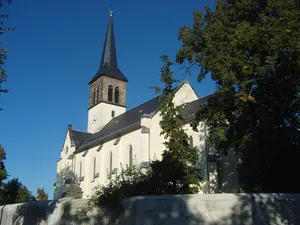 Kirche, fünf Grabmale, eine Grabanlage und Denkmal für die Gefallenen des Ersten Weltkrieges auf dem Kirchhof, zwei Steinbänke und ein Grabmal auf dem Friedhof sowie gesamte Einfriedungsmauer mit fünf schmiedeeisernen Toren (Einzeldenkmale zu ID-