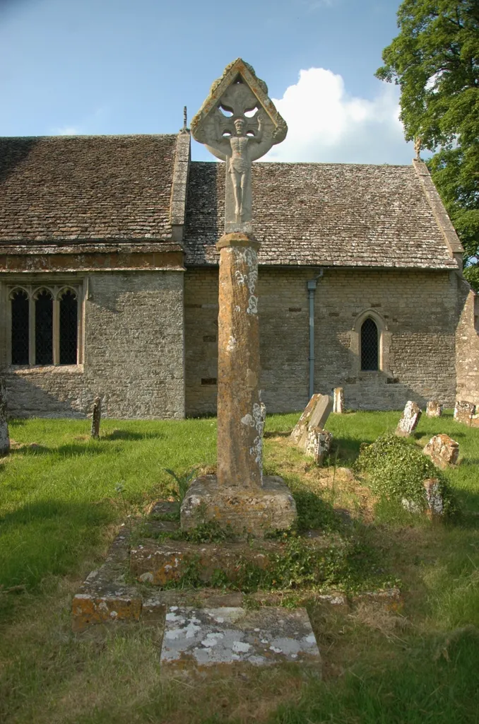Stone cross in St Olave's parish churchyard, Fritwell, Oxfordshire, seen from the south. The base and shaft are Medieval; the stone crucifix was added in 1913.