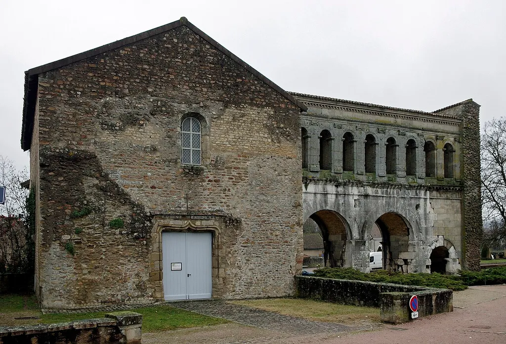 Autun (Saône-et-Loire) Porte Saint-André (Ier siècle av. J.C.). L'enceinte antique d'Autun était percée de quatre portes monumentales, dont trois substistent. La porte d'Arroux, au nord; la porte Saint-André, à l'est; la porte Saint-Andoche, dont il ne subsiste qu'une tour, à l'ouest; la porte de Rome, qui a disparu, au sud. Les quatre portes sont bâties sur le même modèle : deux grandes arches jumelles, pour le passage des chariots, encadrées de deux petites arches pour celui des piétons. Ces arches sont encadrées de deux tours en fer à cheval. Les arches sont surmontées d’une galerie. Les décors de chacune des portes sont par contre différents. Des indices suggèrent qu'il y avait des accès secondaires. La porte Saint-André ouvrait en direction de Langres et Besançon (Vesontio), à l'extrémité est de la rue principale est-ouest (decumanus maximus). Une tour latérale conservée en grande partie a été convertie au Moyen-Âge en église dédiée à Saint-André (actuellement, c'est un petit temple protestant). Au XIXe siècle, Viollet-le-Duc a reconstitué une des arcades piétonnes et couvert la galerie supérieure de tuiles.