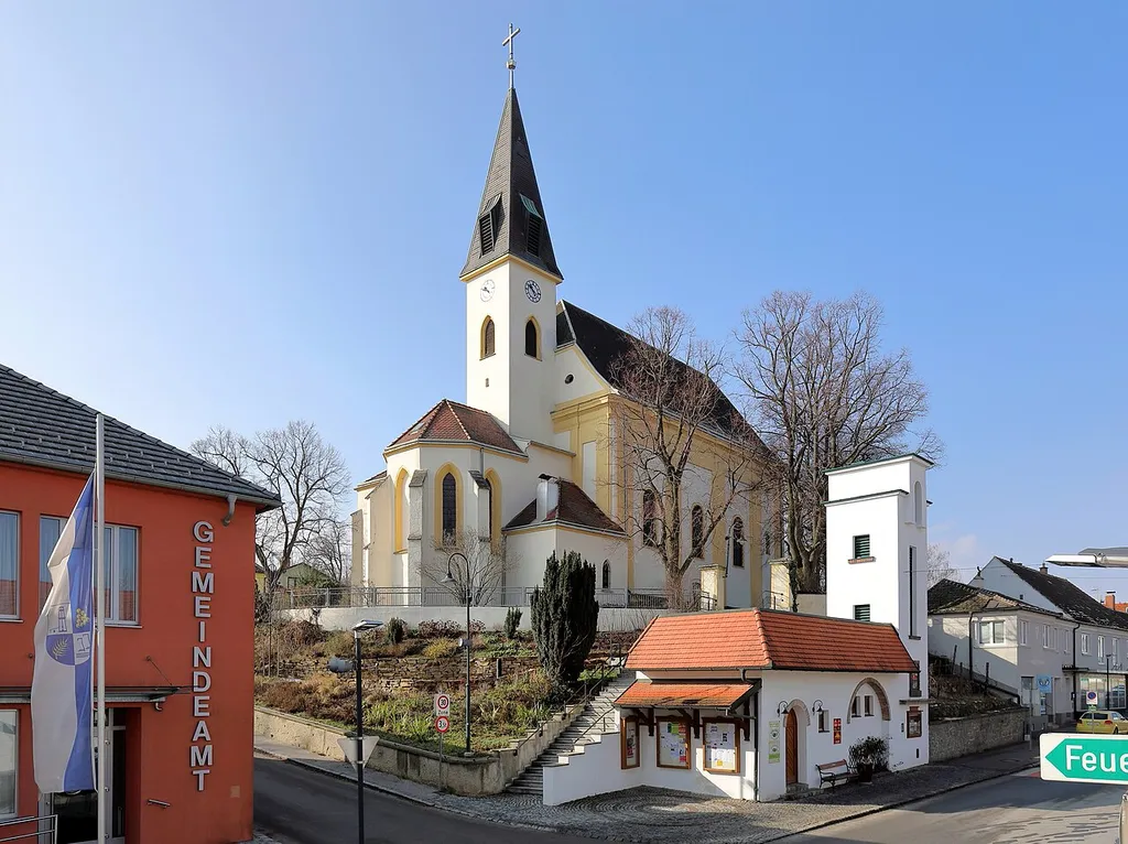 Das Ortszentrum der niederösterreichischen Marktgemeinde Auersthal.Im Zentrum des Bildes die in erhöhter Lage errichtete röm.-kath. Pfarrkirche hl. Nikolaus. Ganz links das Gemeindeamt und unterhalb der Kirche das ehemalige Zeughaus der Feuerwehr. Dieses wurde 1965 anstelle eines Vorgängerbaues errichtet und wird (2018) nach Adaptierung als Weinladen genutzt.