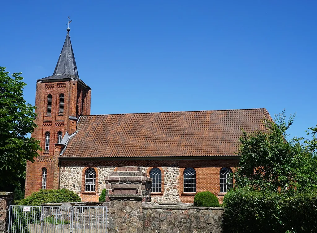Southern view of the St. Peter's Church in Wendhausen in the municipality of Reinstorf, district of Lüneburg. In the foreground the stony war memorial can be seen.