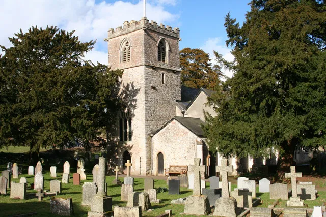 Feniton: St Andrews church. The stumpy tower is almost dominated by the yew trees in the churchyard. Looking north east