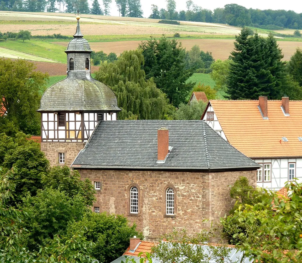 Ev.-luth. Kirche in Reiffenhausen, Gemeinde Friedland, Landkreis Göttingen, Niedersachsen. Buntsandsteinbau, inschriftlich datiert 1742 (Kirchenschiff) und 1796 (Turm), jeweils über dem Eingang. Ein zugesetztes gotisches Portal an der Südseite zeigt, dass die Kirche im Kern älter ist oder Reste eines mittelalterlichen Baus in einen Neubau einbezogen wurden. Ansicht von Südosten vom Hang des Uhlenkopfs.
