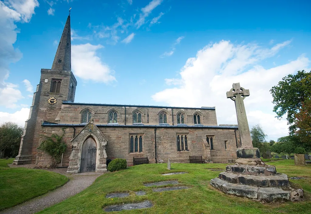 St Michael and All Angels parish church, Hamstall Ridware, Staffordshire, seen from the south. On the right is the churchyard cross.