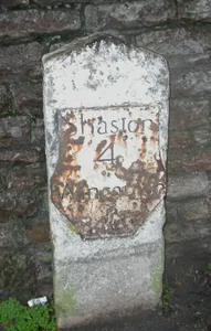 Milestone, by railway bridge