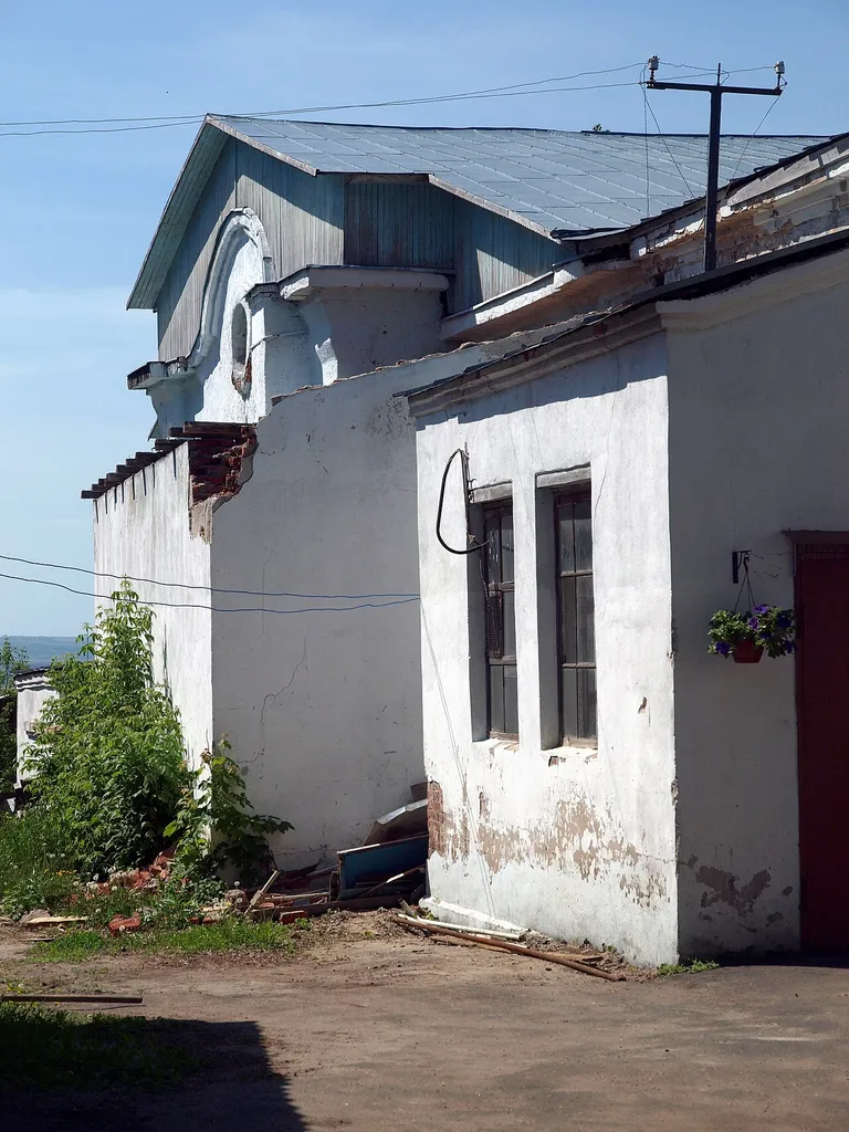 The abbot's house and the church of the Burning Bush of the Nikitsky Convent, Kashira. In the 20th century the property was rebuilt into a knitting factory, and two churches and the house were merged into one structure. View from a narrow alley between the buildings and the fence.