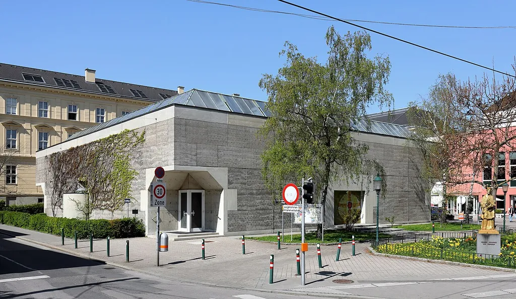 Die Konzilsgedächtniskirche am Kardinal-König-Platz in Lainz, ein Bezirksteil des 13. Wiener Gemeindebezirkes Hietzing.Die Pfarr- und Ordenskirche hl. Ignatius von Loyola wurde ab 1967 nach Plänen von Josef Lackner errichtet und am 22. Juni 1968 geweiht. Bei dem Sichtbetonbau auf quadratischem Grundriss mit flachem Dachaufsatz verzichtete man auf einen Turm.