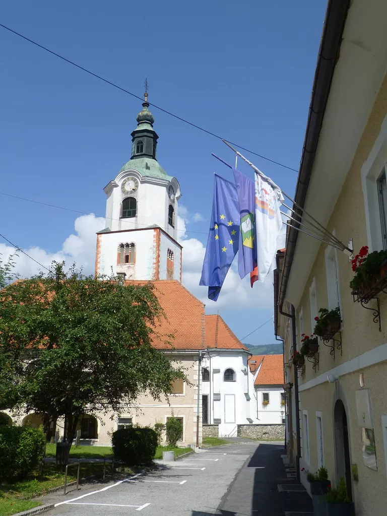 Tower of the Mary Church of Ruše. Probably the town-hall in shadow (flags). Slovenien Styria (Maria-Rast)