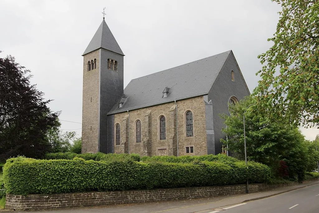 54689 Olmscheid, Hauptstraße 42a. Romanisierender Bruchstein-Saalbau, teilweise verschiefert, 1912–16, Architekt Dombaumeister Julius Wirtz, Trier; mit Ausstattung. Aufnahme von 2018.