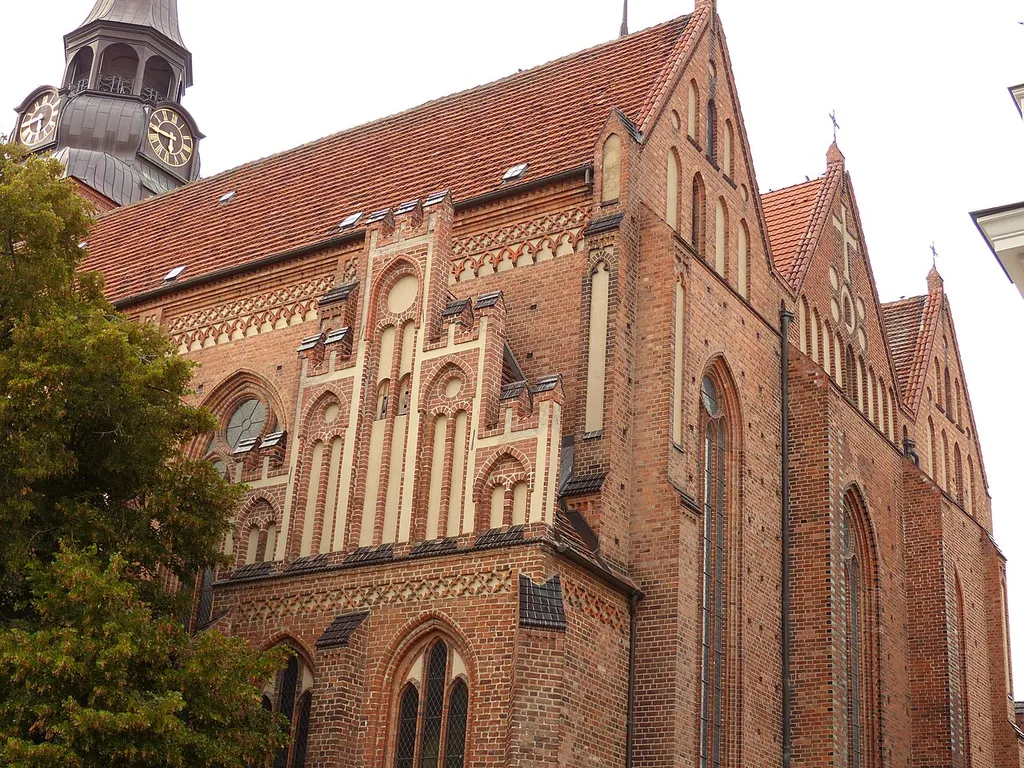 Ostgiebel der Marienkirche in Güstrow von Südosten. Die heute dreischiffige gotische Hallenkirche war vom frühen 16. bis ins späte 19. Jahrhundert fünfschiffig. Sie hat drei parallele Längsdächer. In Deutschland ist das eine Seltenheit, in Flandern und den Niederlanden die häufigste Dachform für Hallenkirchen. Auch die großen Danziger Kirchen, einschließlich der Marienkirche, haben parallele Längsdächer.