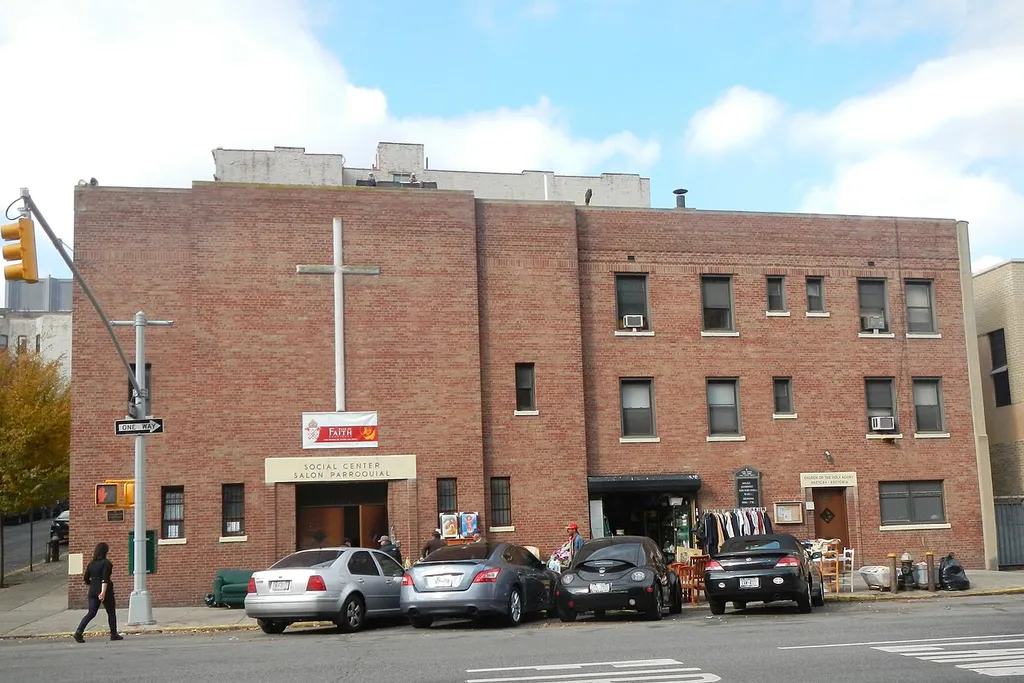 Looking northwest across 3d Avenue at community house and rectory of Church of the Holy Agony on a mostly sunny midday.