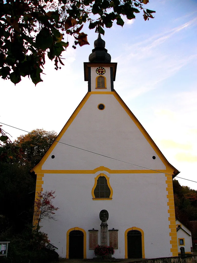 Aus einer Burgkapelle hervorgegangener Saalbau mit eingezogenem 5/8-Chorschluss, dort Strebepfeiler mit Architekturplastik, Walmdach und Dachreiter, 1550 vom Wiener Weihbischof Friedrich Grau (Nausea) begonnen, das Langhaus 1552-1554 vereinfacht zu Ende geführt, 1585 geweiht, Westfassade 1750-1756 von Wenzel Schwesner, Sakristei 1895; mit Ausstattung; davor Kriegerdenkmal für die Gefallenen des Ersten Weltkrieges, Kalksteinpfeiler mit thronender Mutter Gottes auf Sockel, an der Kirchenfassade zwei Steintafeln mit den Namen der Gefallenen des Zweiten Weltkrieges