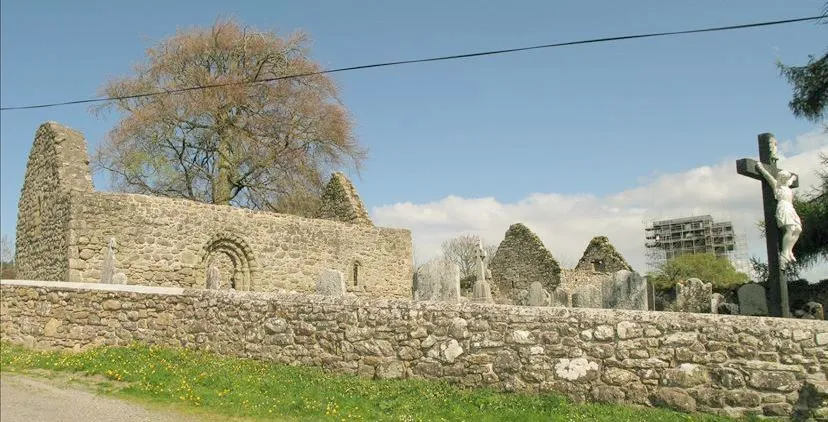 Ancient churchyard near Kilcash, County Tipperary, Ireland with view of castle undergoing stabilisation works in background.