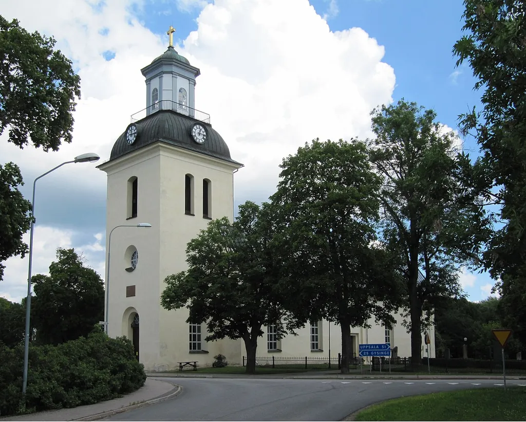 Östervåla kyrka. Länsväg 272 passerar framför kyrkans ingång i väster.