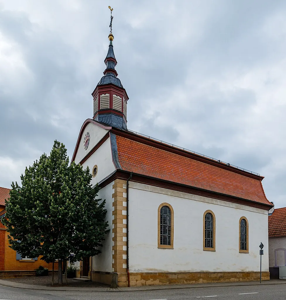 This is a photograph of a cultural monument.It is on the list of cultural monuments of Hochdorf-Assenheim. Depicted part: Face and longitudinal side Designation: Protestant parish church Construction time: 1752–1758 Description: Late baroque hall building with mansard roof townscape formative Place: Quarter Assenheim, Local municipality Hochdorf-Assenheim, Collective municipality Dannstadt-Schauernheim, Local government Rhein-Pfalz-Kreis, Rhineland-Palatinate, Germany Location: Langstraße House number: 23