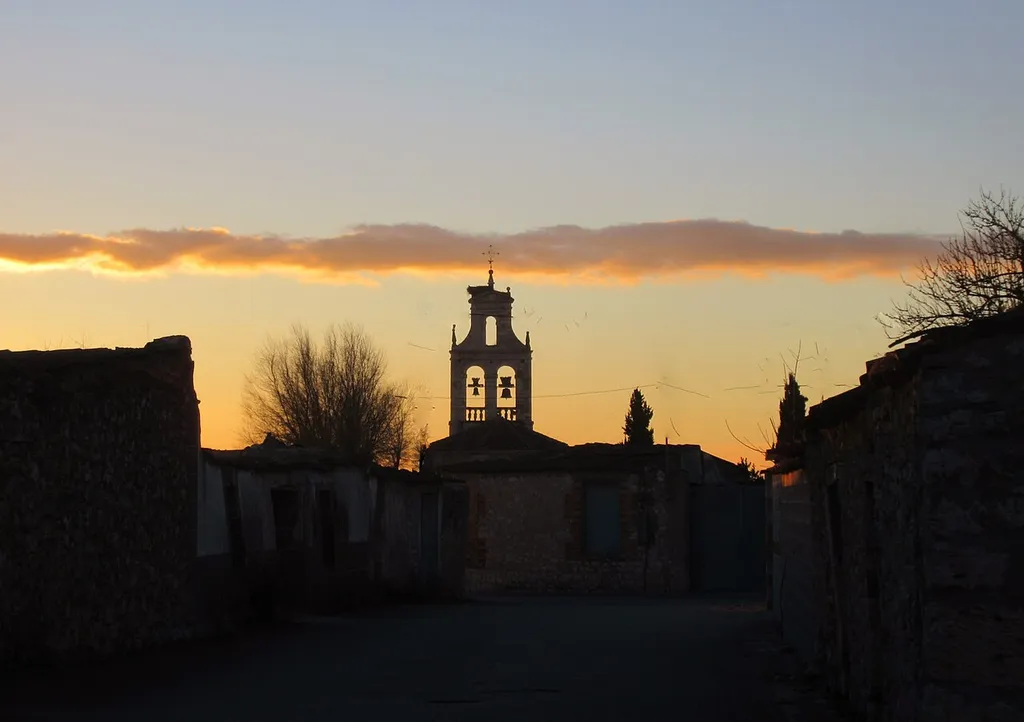 La tranquilidad crepuscular en un pueblo castellano. Calle de Escarabajosa de Cuéllar con la espadaña de la Iglesia de Santa María la Nueva.