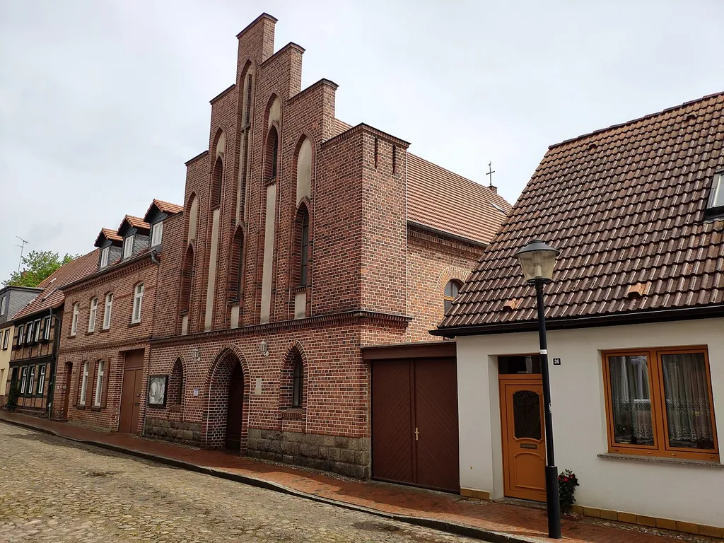 Straßenansicht der ehemaligen Synagoge, die 1845 erbaut und 1917 verkauft wurde. Zwischenzeitlich Speicher, Werkstatt und Kunstdüngerlager. Seit 1925 als römisch-katholische Kirche "Heilige Familie" genutzt.