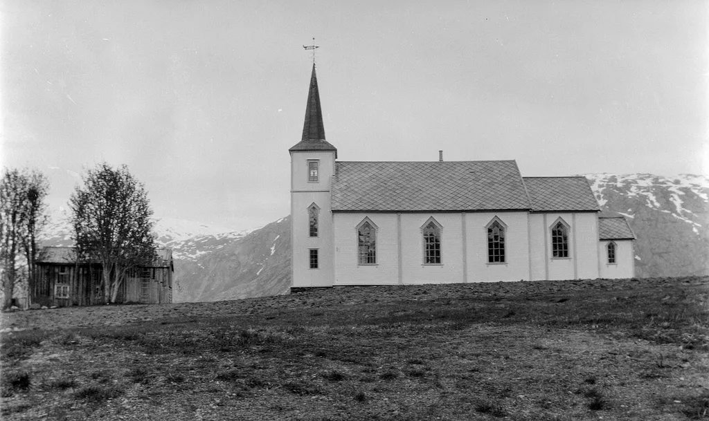 Bardal kirke ved Bardalsjøen, ca. 1920–1940. Kirken har siden fått tilbygg på siden av tårnet og takstein av tegl istedenfor skifer.
