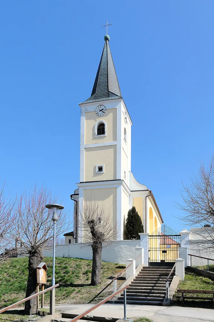 Westansicht der römisch-katholischen Pfarrkirche hl. Margaretha in Schrick, ein Ortsteil der niederösterreichischen Marktgemeinde Gaweinstal.Die Kirche mit eingezogener Rundapsis und einem vorgestellten Westturm wurde 1688/91 auf einem Hügel im Südosten des Ortes errichtet und ist von einem Friedhof umgeben.