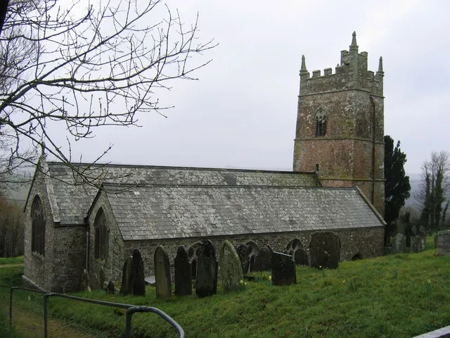 St Anne's Church, Whitstone. Taken from the NE entrance to the churchyard. An ancient wellhouse is in the SE corner of the churchyard. An old stone face stares out from the rear of the well.