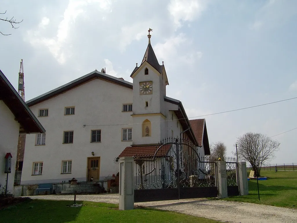 Rasch 2, Gemarkung Mühlhausen, Gemeinde Mengkofen, Niederbayern. Ehem. Klostermaierhof; ehem. Wohnstallhaus, zweigeschossiger Satteldachbau mit befenstertem Kniestock, im Kern 18.Jh.; Kapelle mit Lourdes-Grotte, in pittoreskem Uhrturm von 1907; Stall, in Teilen erhalten, bez. 1907.