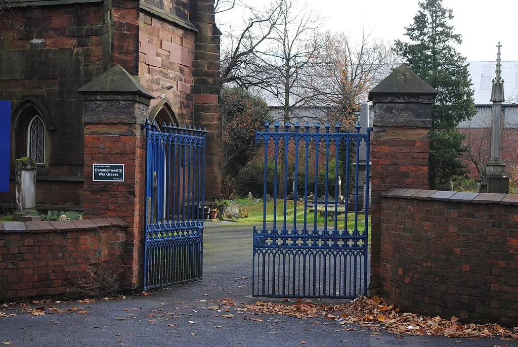 St John the Evangelist's Church, Perry Barr, Birmingham, England. The gates and gateposts are listed, separately to the church. Which almost certainly means that the CWGC sign should not be fixed to them!