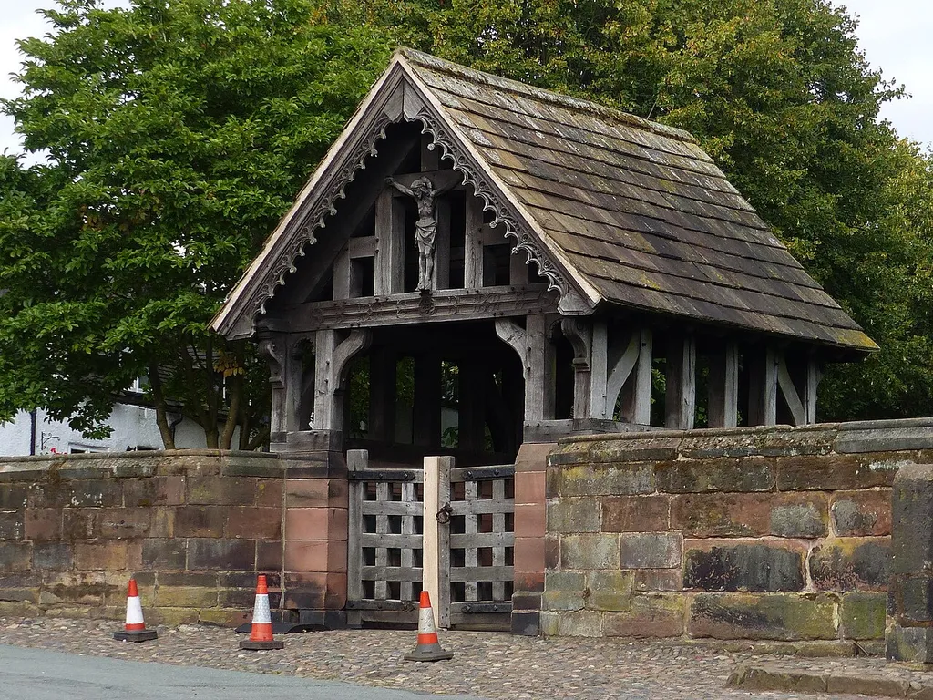 Lychgate to churchyard of St Mary and All Angels: Grade II listed building in Great Budworth, Cheshire. .mw-parser-output .messagebox{margin:4px 0;width:auto;border-collapse:collapse;border:2px solid var(--border-color-progressive,#6485d1);background-color:var(--background-color-neutral-subtle,#fbfcff);color:var(--color-base,#202122);box-sizing:border-box;border-inline-start-width:8px}.mw-parser-output .messagebox.mbox-small{font-size:88%;line-height:1.25em}.mw-parser-output .mbox-warning,.mw-parser-output .mbox-speedy{border:2px solid var(--border-color-error,#b22222);background:var(--background-color-error-subtle,#ffdbdb);border-inline-start-width:8px}.mw-parser-output .mbox-serious,.mw-parser-output .mbox-delete,.mw-parser-output .mbox-stop{border:2px solid var(--border-color-error,#b22222);border-inline-start-width:8px}.mw-parser-output .mbox-issue,.mw-parser-output .mbox-content{border:2px solid #f28500;background:var(--background-color-warning-subtle,#ffe);border-inline-start-width:8px}.mw-parser-output .mbox-query,.mw-parser-output .mbox-style{border:2px solid #f4c430;background:var(--background-color-warning-subtle,#ffe);border-inline-start-width:8px}.mw-parser-output .mbox-shit{border:2px solid #960;border-inline-start-width:8px}.mw-parser-output .mbox-license{border:2px solid #88a;border-inline-start-width:initial}.mw-parser-output .mbox-legal{border:2px solid var(--border-color-notice,#666);background:var(--background-color-base,#fff);border-inline-start-width:8px}.mw-parser-output .mbox-honor{border:2px solid #ca3;background:var(--background-color-warning-subtle,#fcf4db);border-inline-start-width:8px}.mw-parser-output .mbox-growth{border:2px solid #8d4;background:var(--background-color-success-subtle,#d5fdf4);border-inline-start-width:8px}.mw-parser-output .mbox-move{border:2px solid #93c;border-inline-start-width:8px}.mw-parser-output .mbox-protection,.mw-parser-output .mbox-message{border:2px solid var(--border-color-base,#aaa);border-inline-start-widt