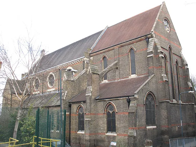 St Michael &amp; All Angels church, Woolwich The church is on Borgard Road. This is the liturgical east end (but actually facing south-east). It was built c. 1878-1889 but there was never sufficient money to complete the original designs of the architect (William Butterfield, who was also responsible for Melbourne Cathedral, Australia with which it shares several architectural details). The south aisle and tower were constructed in 1954 to the designs of Thomas Ford. The church is listed grade C. For a view of the west end see 972047.