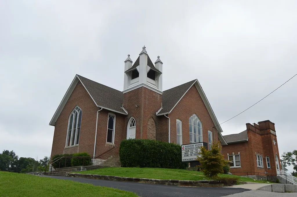 Front and southern side of the Burnside Methodist Church, located on the western side of Central Avenue in Burnside, Kentucky, United States. Built in 1907, it is listed on the National Register of Historic Places, along with the Burnside Masonic Lodge building visible to the rear.