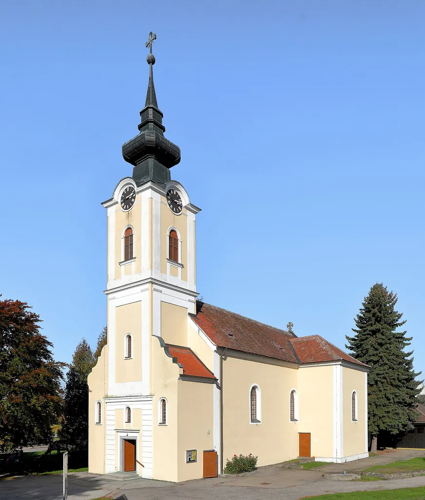 Südwestansicht der röm.-kath. Pfarrkirche hll. Märtyrer Johannes und Paulus in Zissersdorf, ein Ortsteil der niederösterreichischen Stadt Drosendorf-Zissersdorf.Die Saalkirche mit rundem Chorschluss wurde im josephinischen Stil errichtet. Der 37 m hohe Zwiebelturm ist zwischen niedrigen Anbauten eingestellt. Von 1906 bis 1908 wurde die Kirche umgebaut und erweitert. Dabei erhielt die Kirche einen Sakristeitrakt und eine Marienkapelle, die querhausartig angebaut wurden.