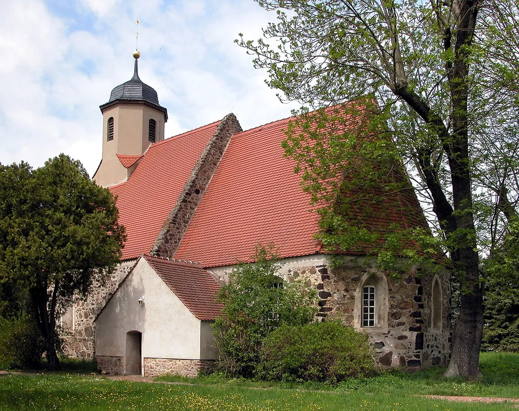 08.05.2015 03249 Zeckerin (Sonnewalde), Dorfstraße 34A: Spätgotische Feldsteinkirche (GMP: 51.711797,13.632377) aus kurzem Schiff und eingezogenem, dreiseitig geschlossenem Chor. In ihm haben sich zwei gotische Spitzbogenfenster erhalten. Auf der Südseite gibt es zwei gestufte Backsteinportale: Das zum Schiff ist zugesetzt, das zum Chor liegt hinter der barocken Südvorhalle und weist auf seinem Türblatt spätgotische Beschläge auf. [DSCN5312JPG]20150508115DR.JPG(c)Blobelt