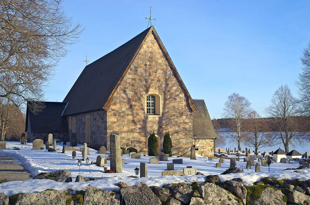 Träden kastar skuggor över Länna kyrkas västra sidor